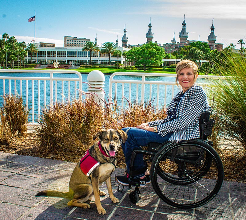 Headshot of Pamela A. Walton & her dog Vinnie infront of the University of Tampa